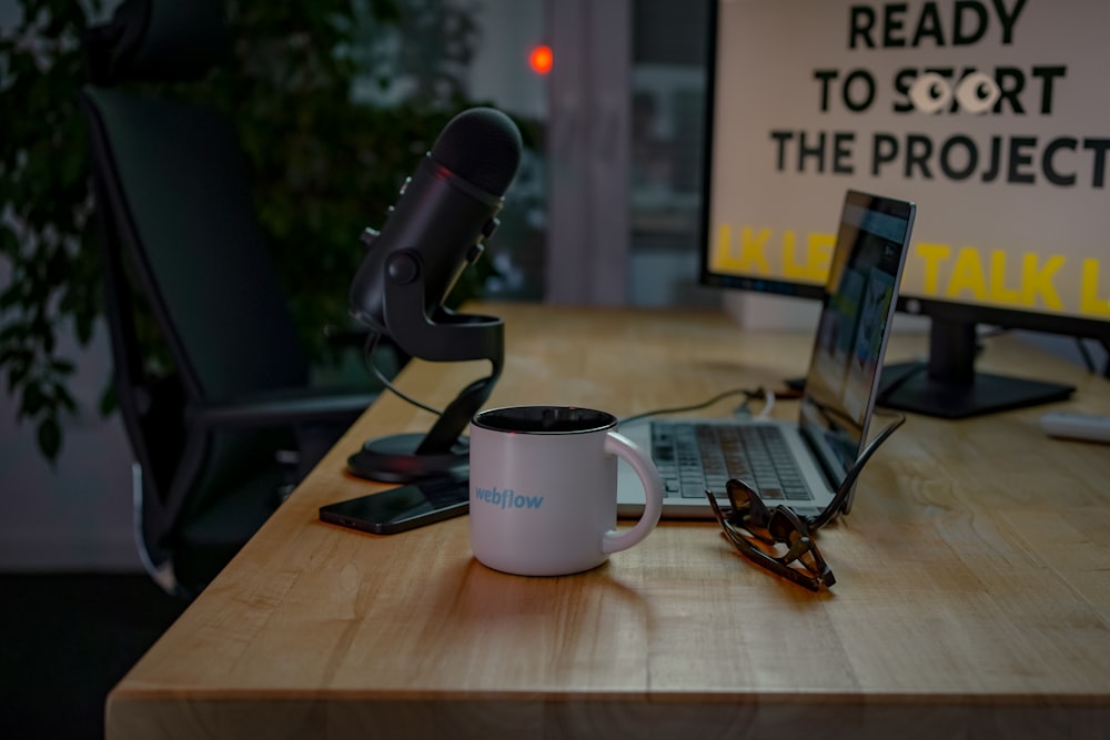 a desk with a laptop and a coffee mug on it