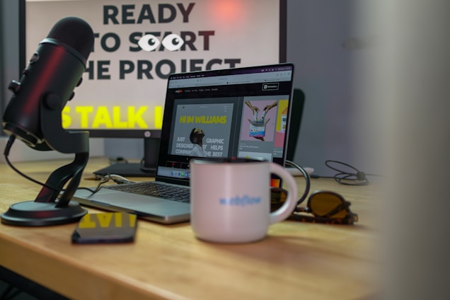 A cozy desk with a microphone and laptop, capturing the essence of storytelling through speech technology.