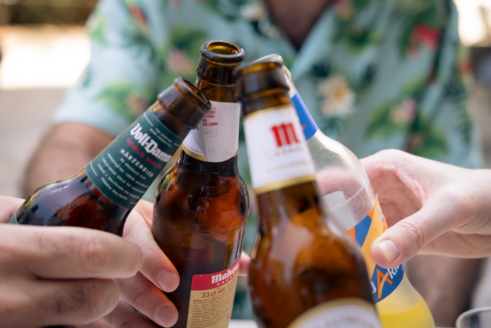 a group of people holding up beer bottles