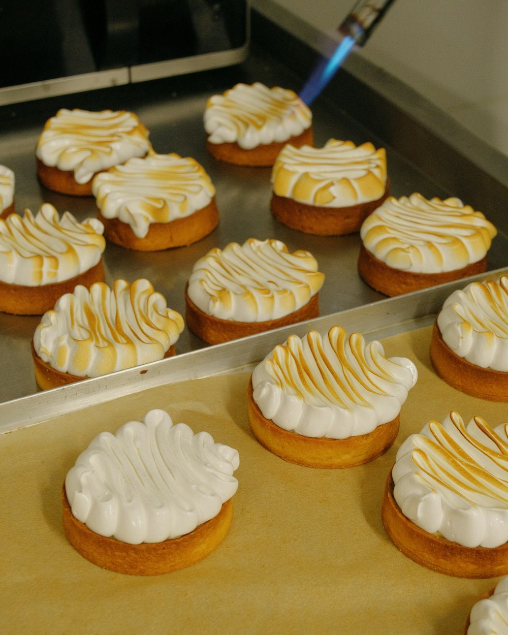 a tray of cookies with white frosting on them