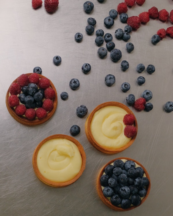 Three desserts with berries and blueberries on a table