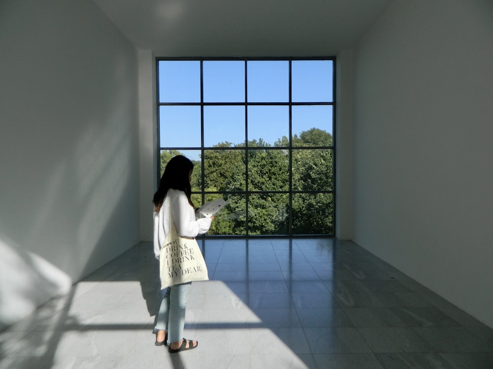 a woman standing in a room looking out a window