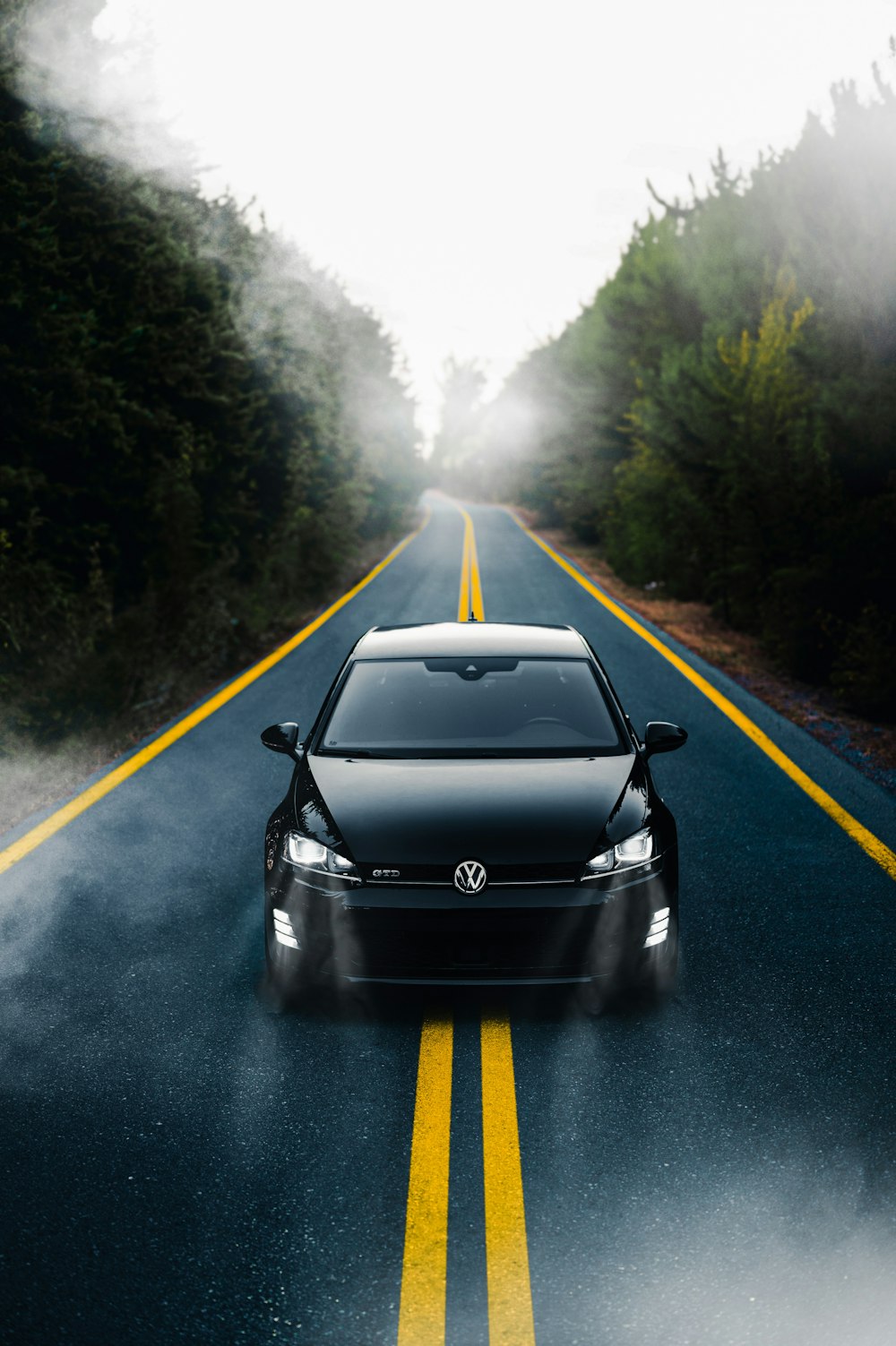 a car driving down the road in the fog