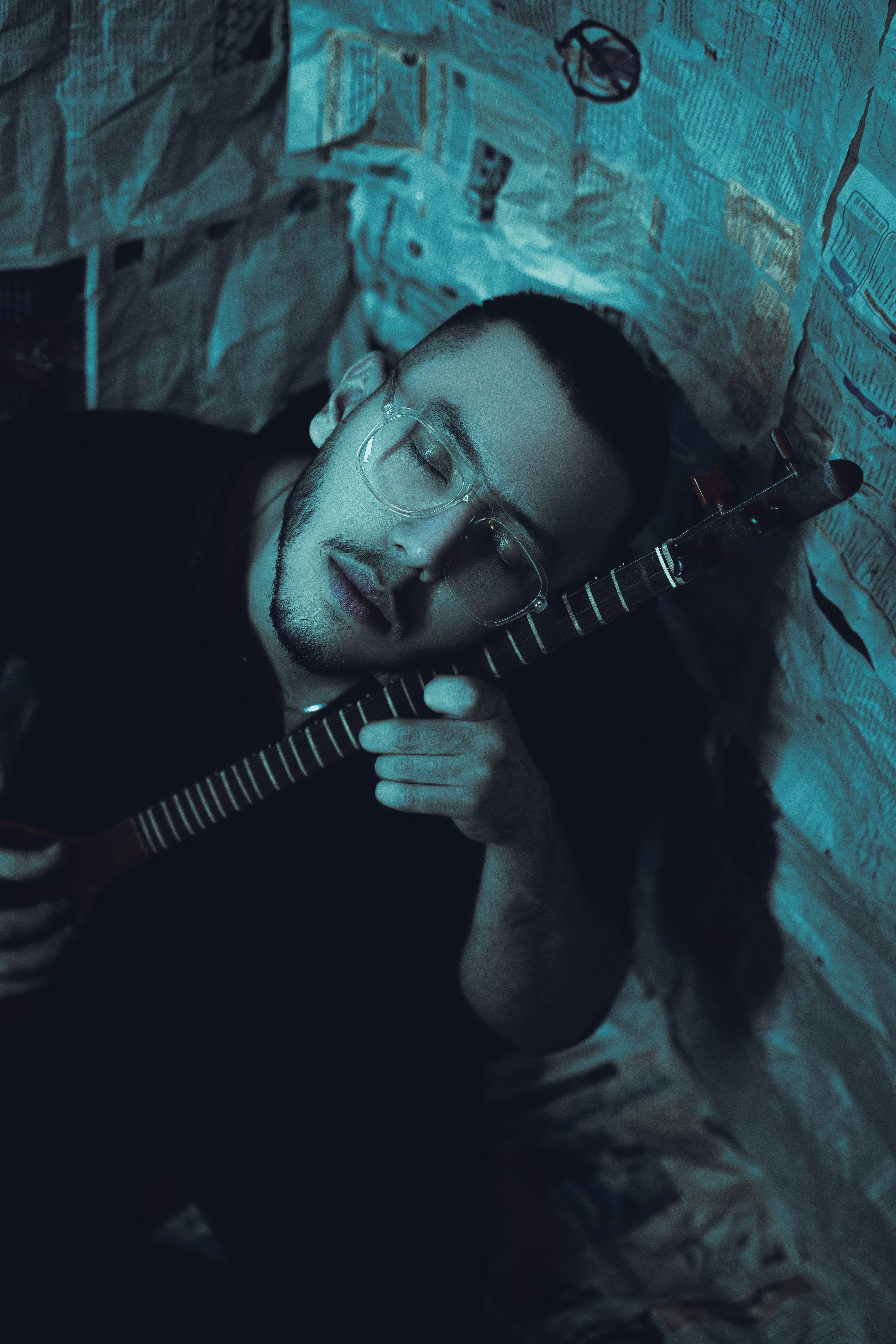 Un uomo con gli occhiali tiene in mano una chitarra