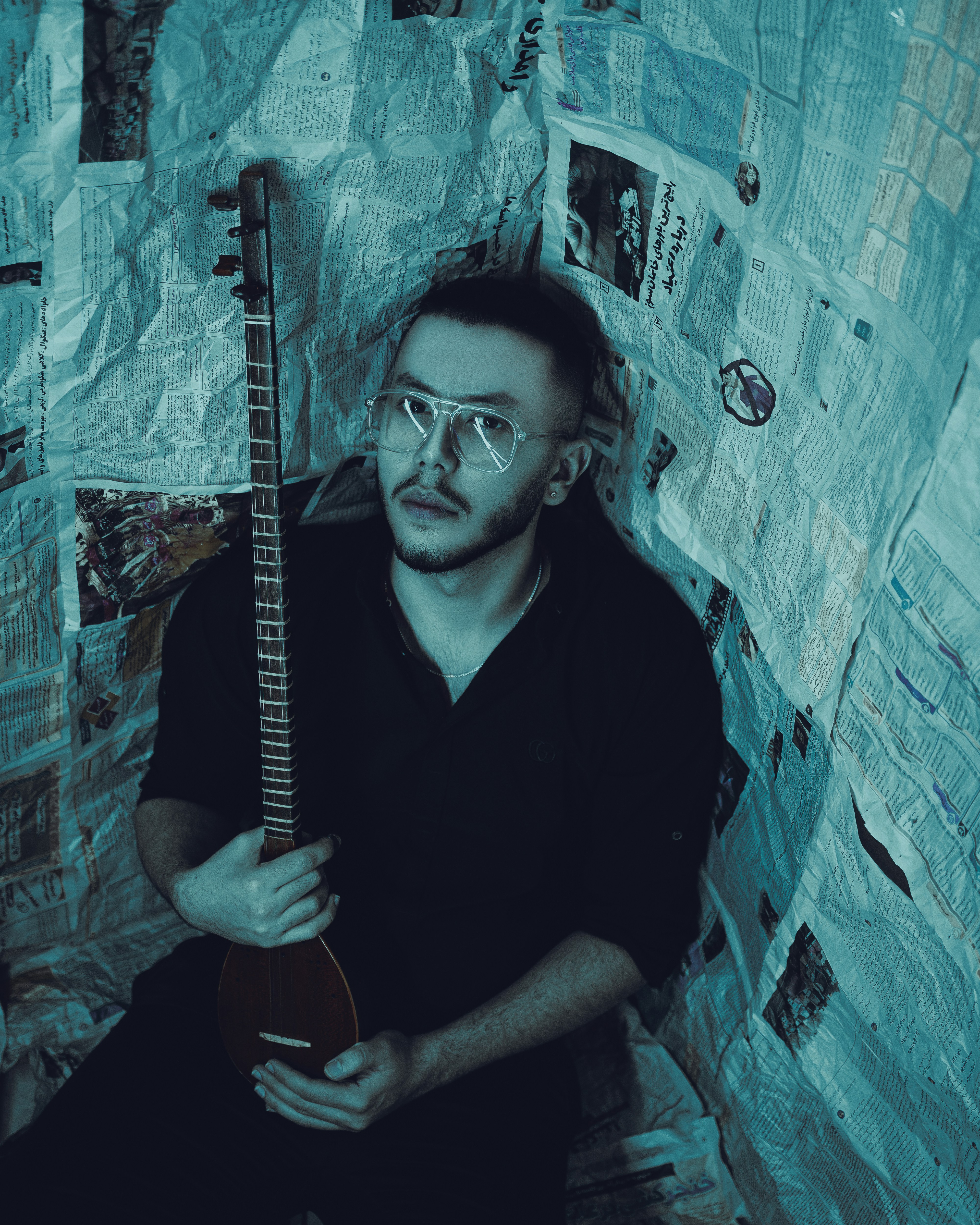 Un uomo seduto su un letto che tiene una chitarra