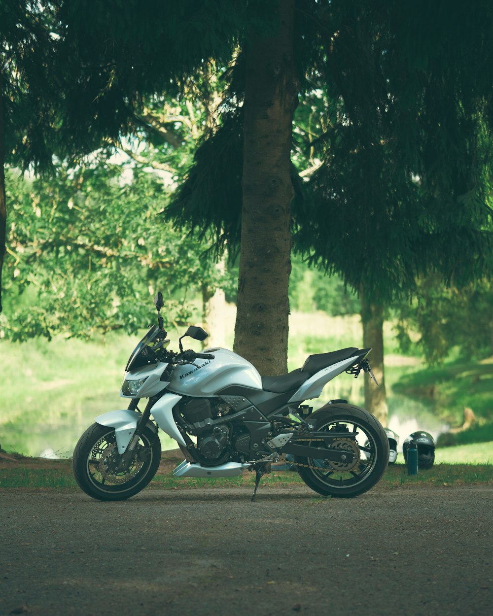 a motorcycle parked in the shade of a tree