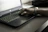 A stylish person wearing multiple sleek bracelets while typing on a laptop.