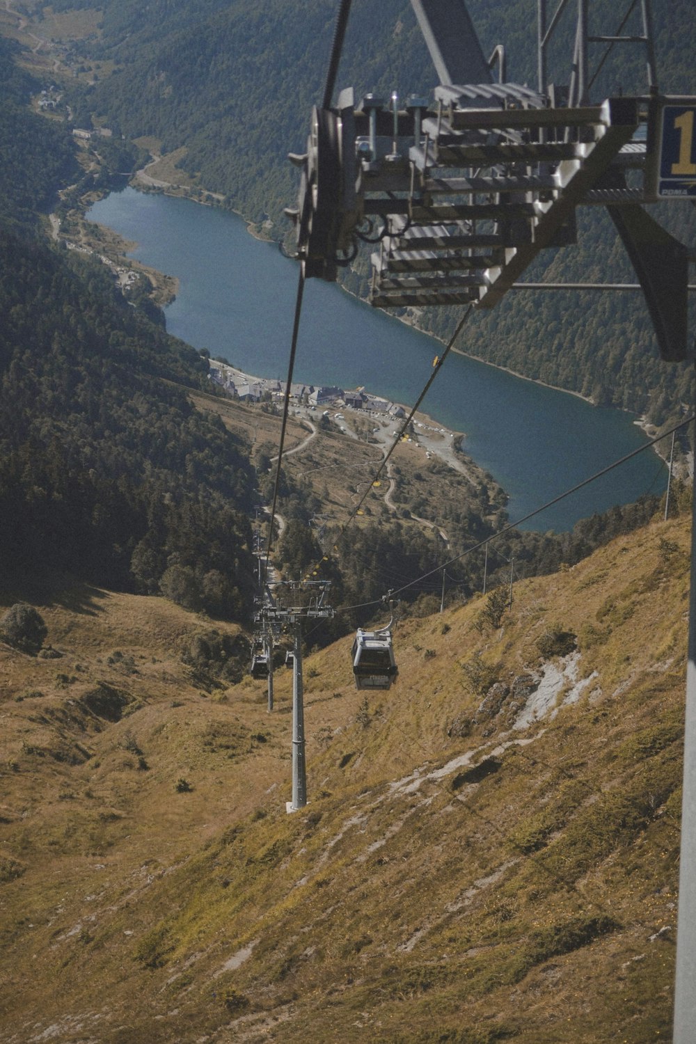 a ski lift going up a hill with a lake in the background