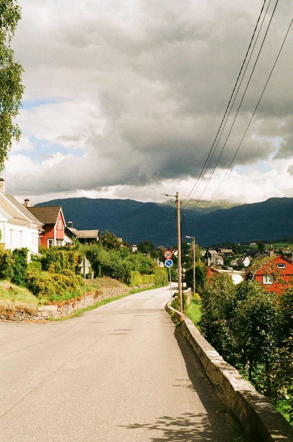 a street with houses on both sides and mountains in the background