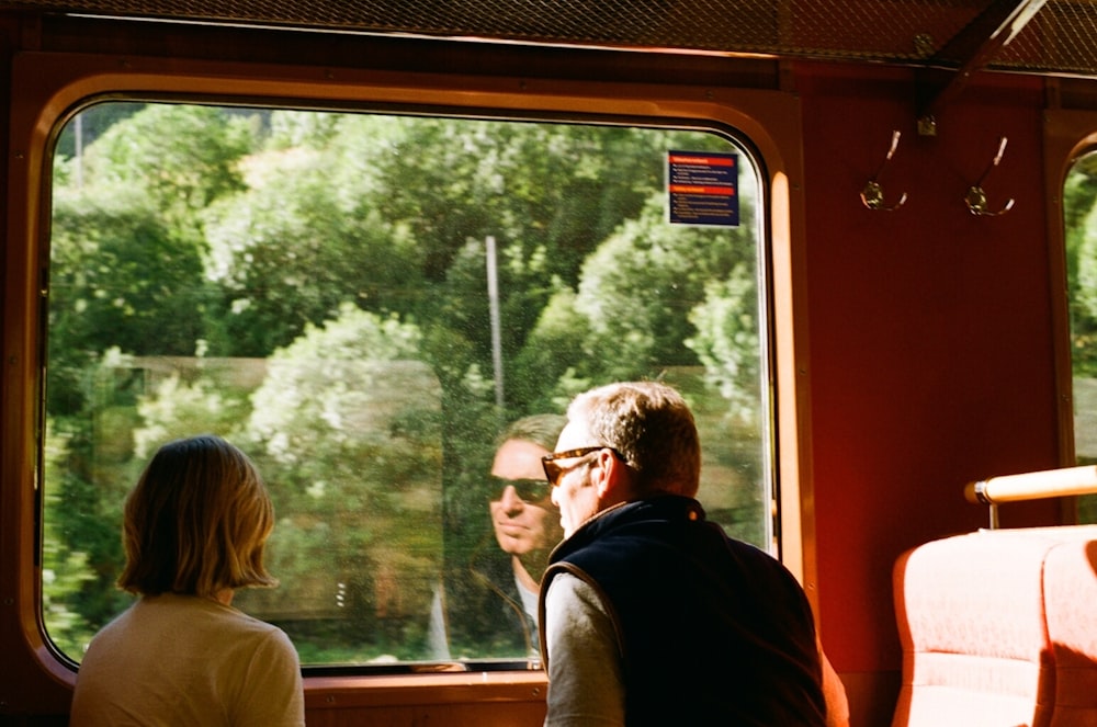 a man and a woman looking out a train window
