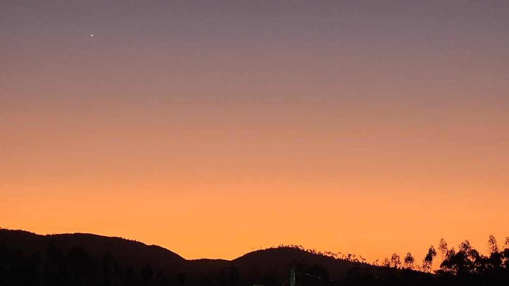 Ein Flugzeug fliegt bei Sonnenuntergang am Himmel