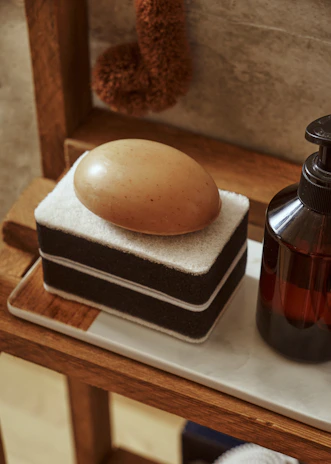 An inviting soap rack holding handcrafted soaps in earthy tones beside a rustic sink.