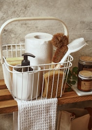 a white basket filled with lots of bathroom items