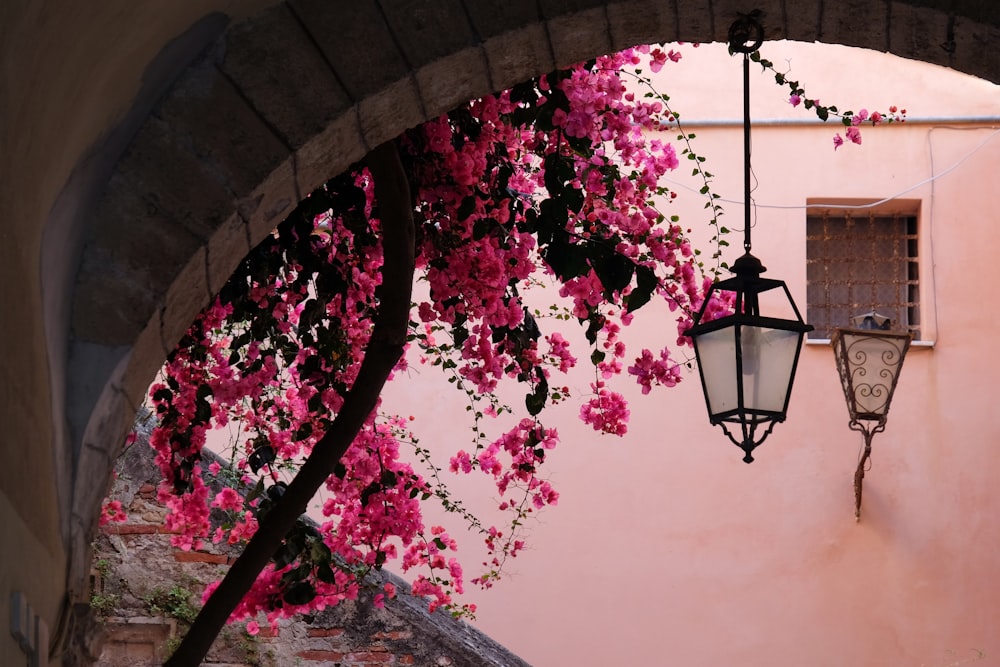 a street light hanging from the side of a pink building