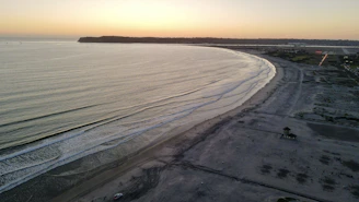 Aerial view of Garopaba coastline at sunset with calm waves and sandy beaches.