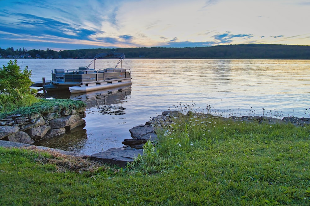 a boat is docked on the shore of a lake