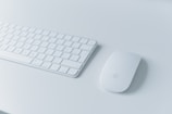 Close-up of a sleek wireless keyboard and mouse on a modern desk.