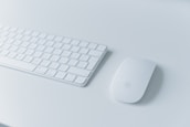A modern wireless keyboard and mouse set on a stylish desk.