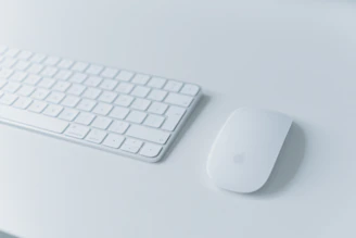 A sleek wireless mouse and keyboard set displayed on a modern desk.
