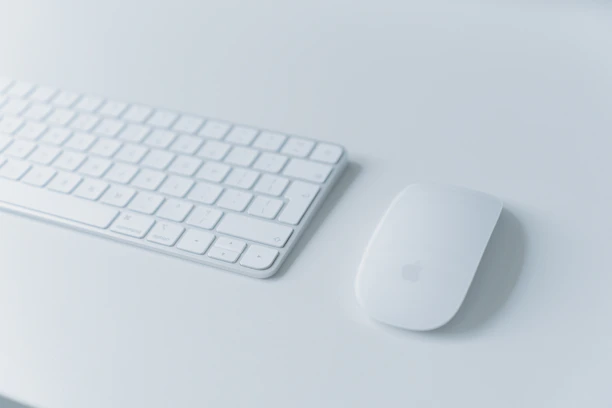 A sleek wireless mouse and keyboard set displayed on a modern desk.