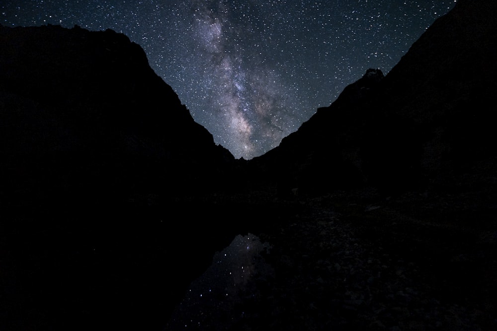 the night sky is filled with stars above a mountain range