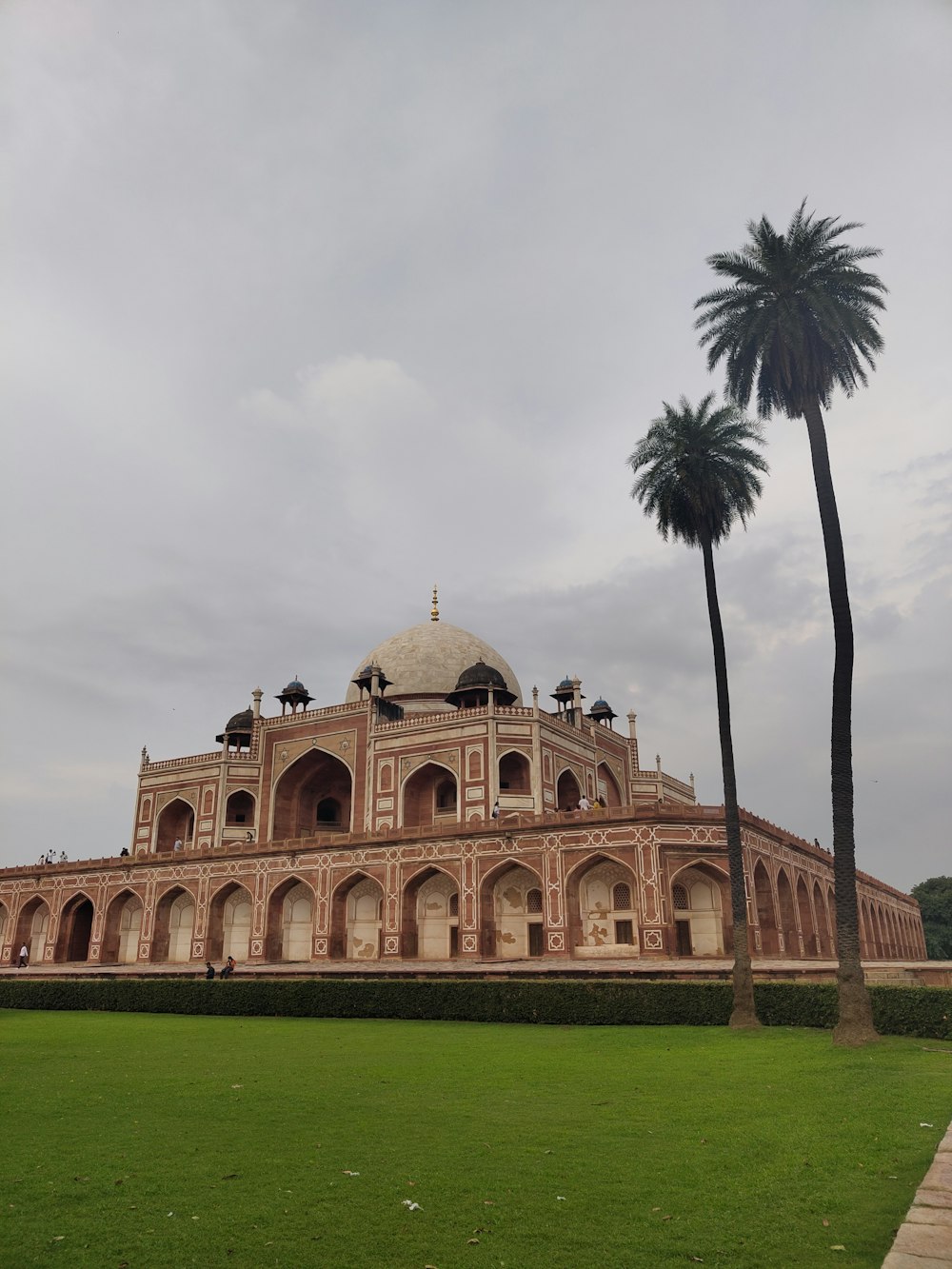 a large building with two palm trees in front of it