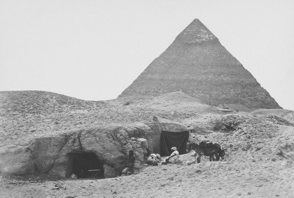 um grupo de pessoas em frente a uma pirâmide