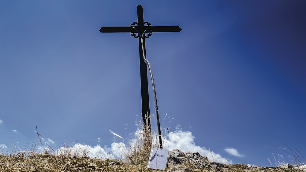 a cross on top of a hill with a sign on it
