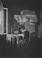 A candid photo of Benita Cruikshank writing at her cozy desk by a window.