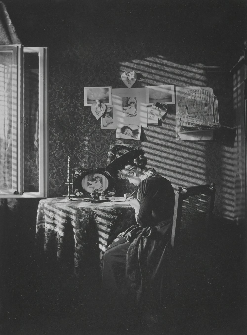 a black and white photo of a woman sitting at a table