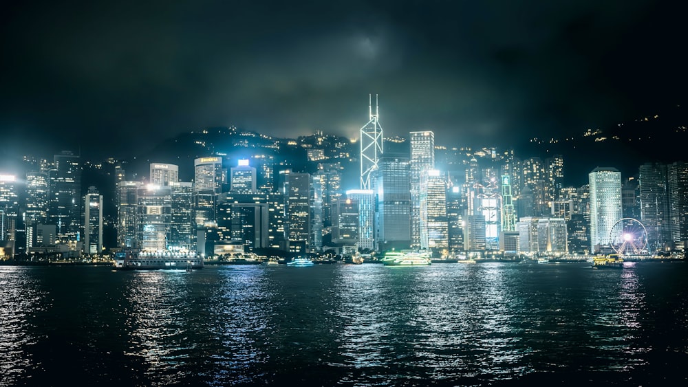 a city skyline at night with lights reflecting off the water