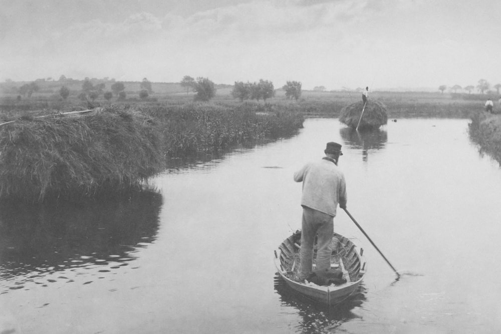 a man standing in a boat on a river