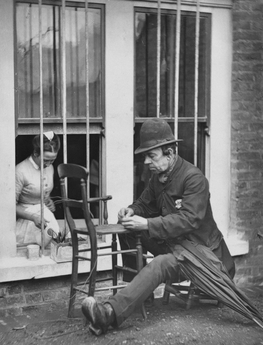 a black and white photo of a man sitting in a chair