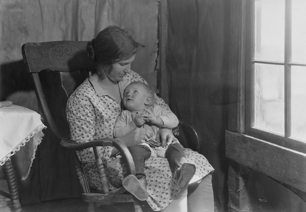 a woman sitting in a rocking chair holding a baby