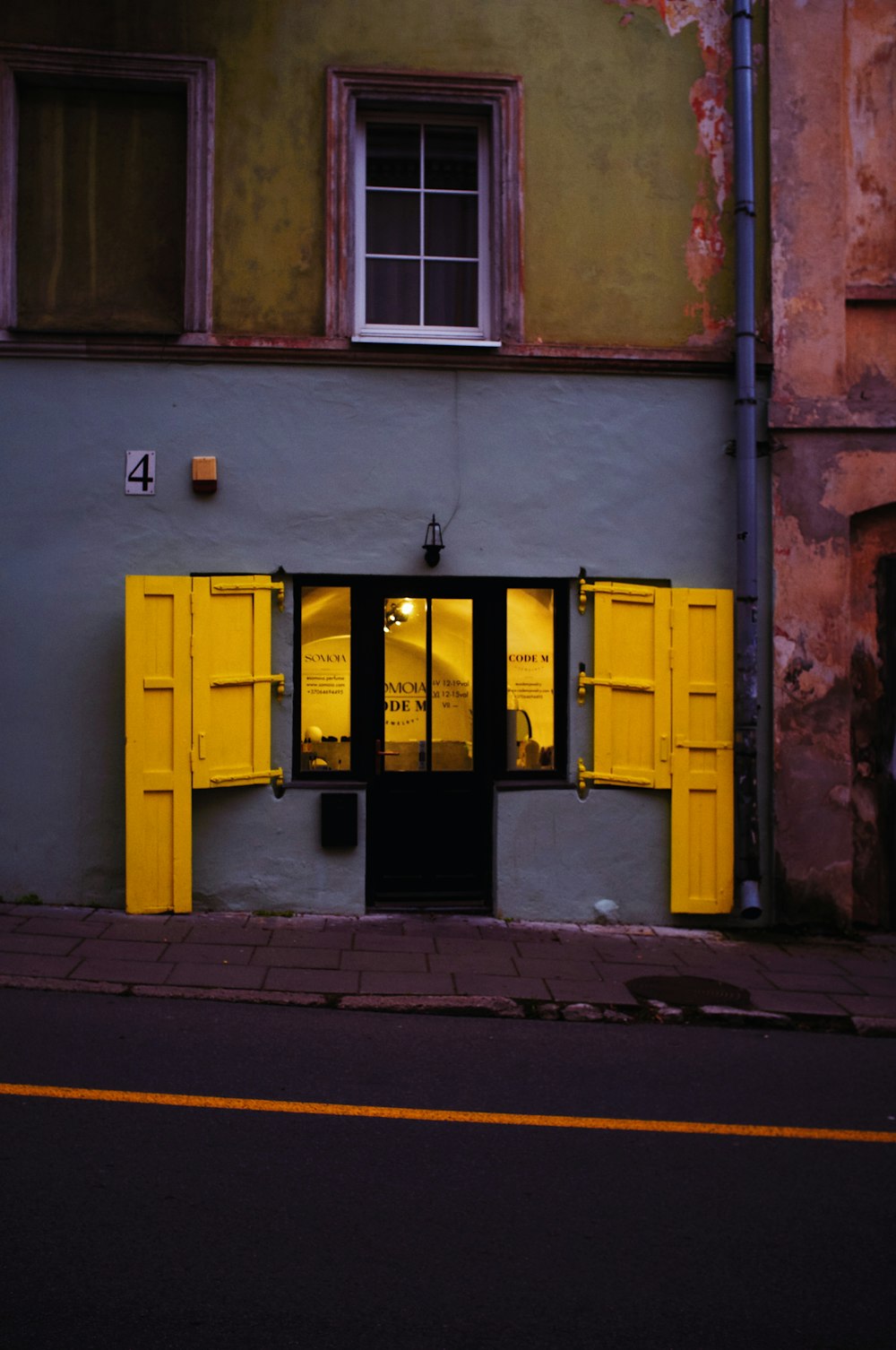 a building with yellow shutters on the front of it