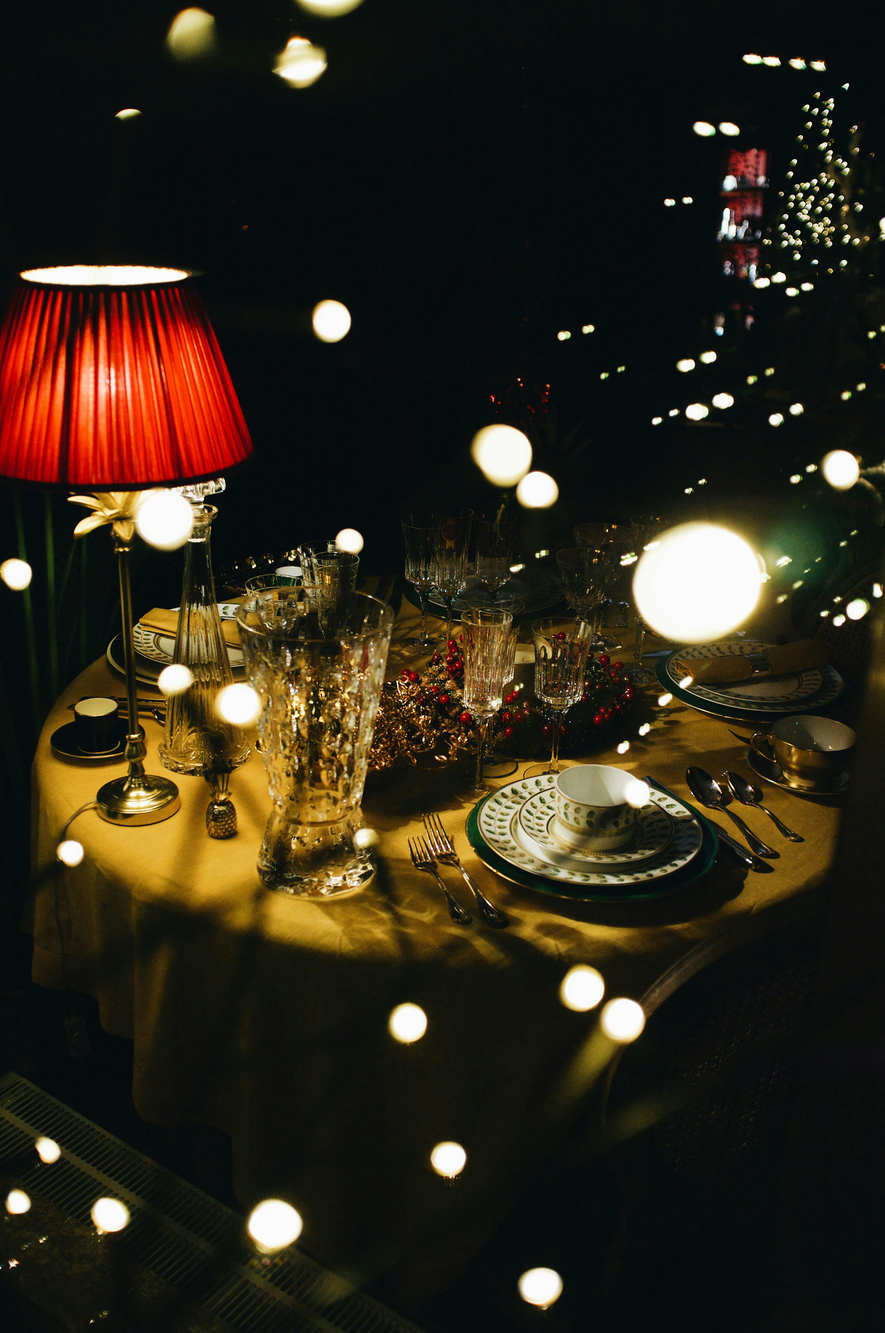 a table is set with a red lamp and plates