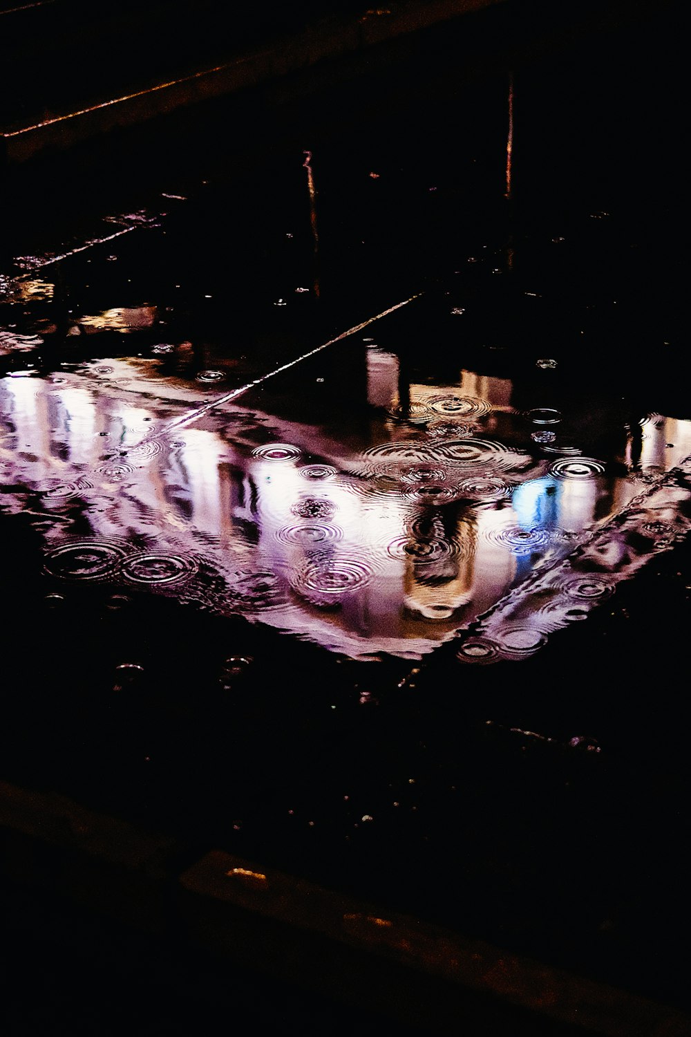 a reflection of a building in a puddle of water