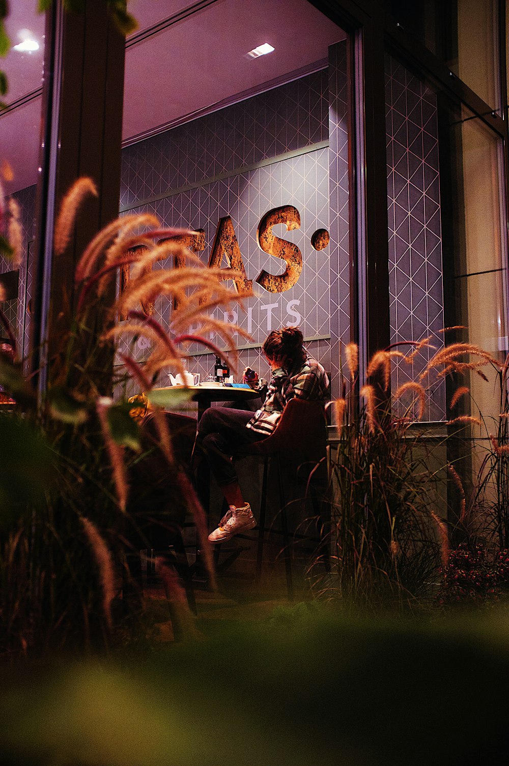 a person sitting at a table in front of a window