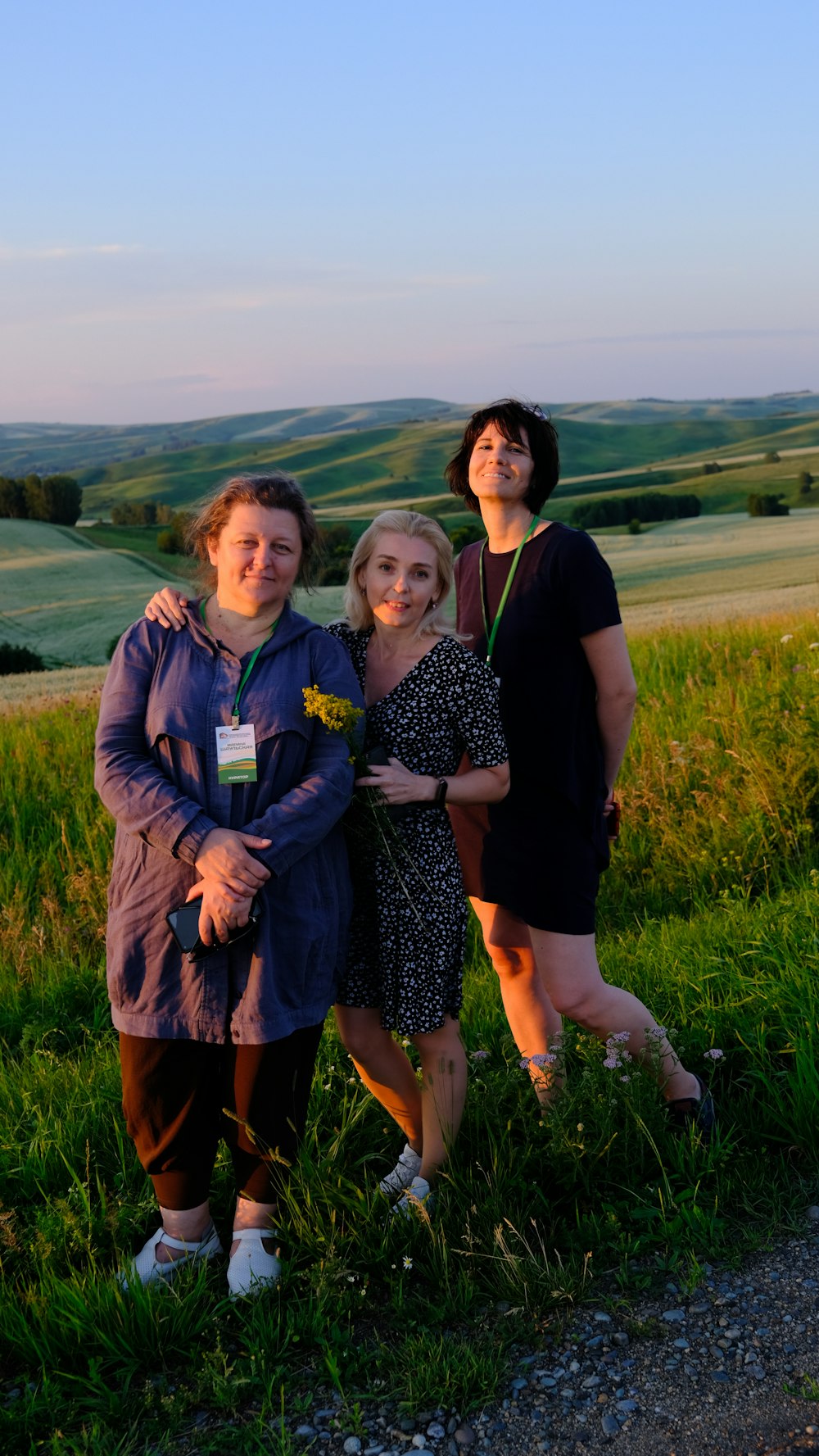 eine gruppe von frauen, die nebeneinander auf einer üppigen grünen wiese stehen