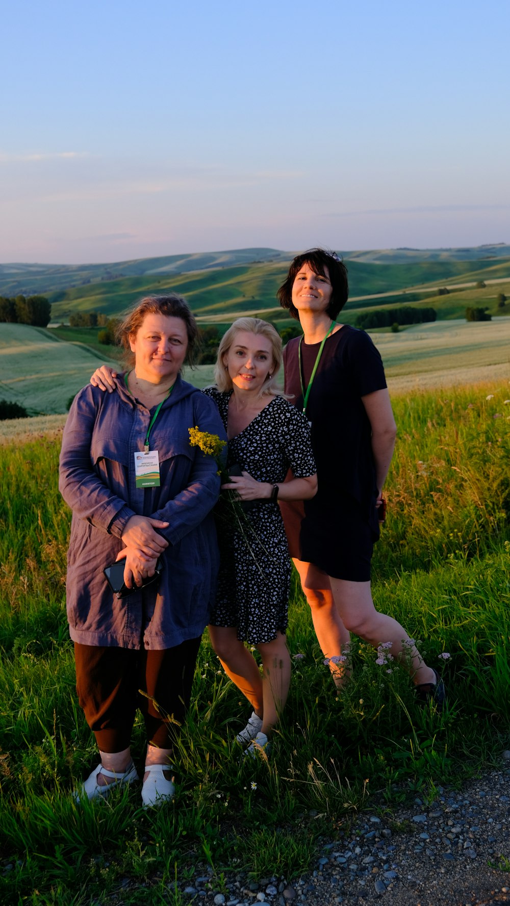 a group of women standing next to each other on a lush green field