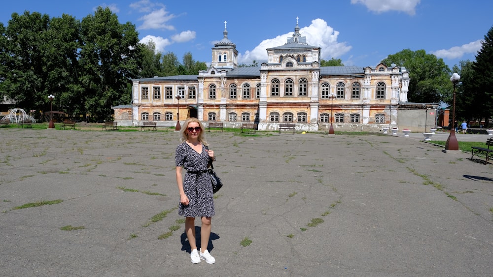 a woman standing in front of a large building