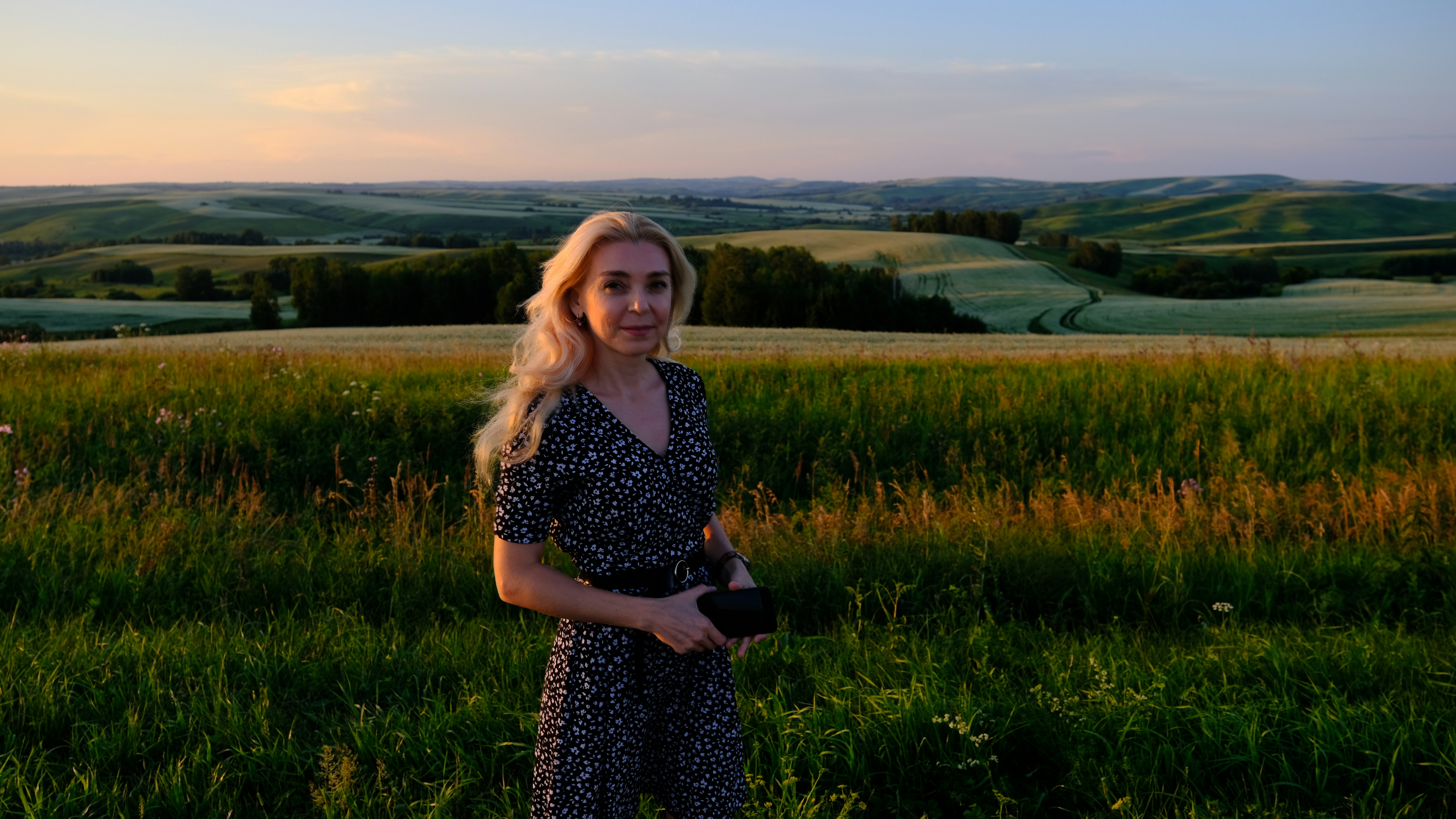 a woman standing in a field of tall grass