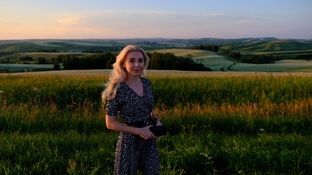 uma mulher em pé em um campo de grama alta