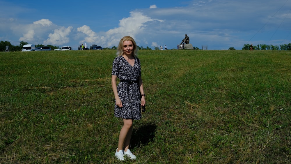 a woman in a dress standing in a field