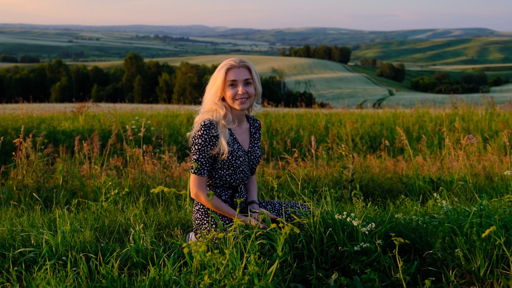 una donna seduta in un campo di erba alta