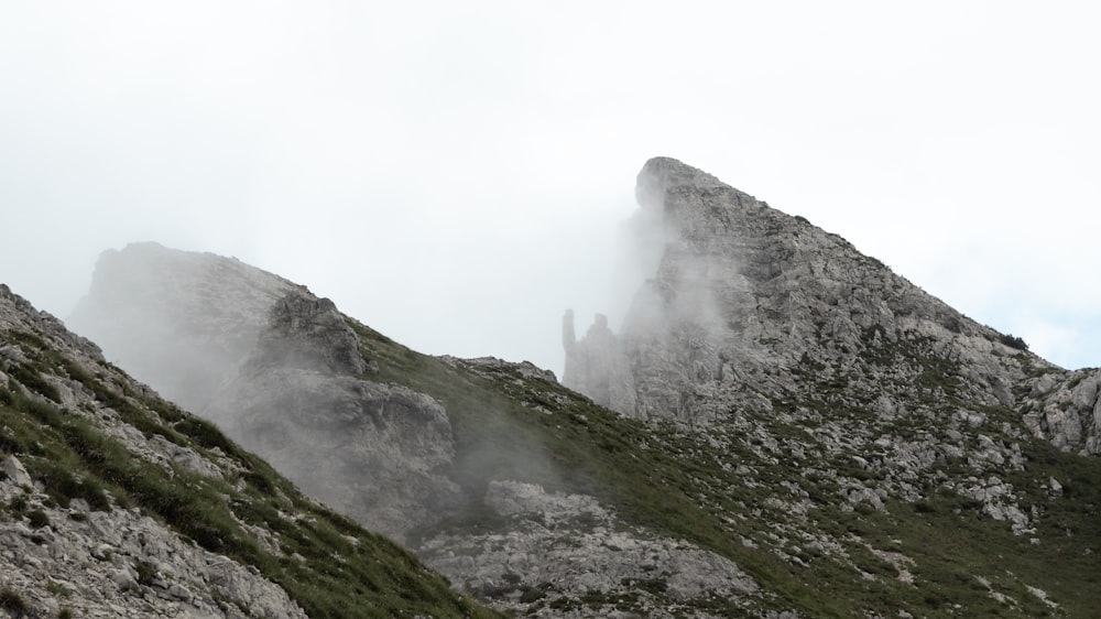 a very tall mountain covered in fog on a cloudy day
