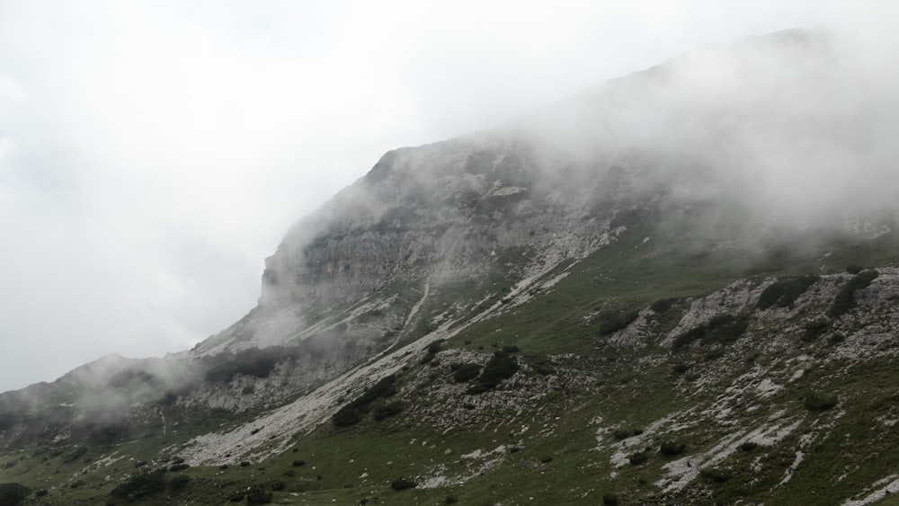 a mountain covered in fog and clouds on a cloudy day