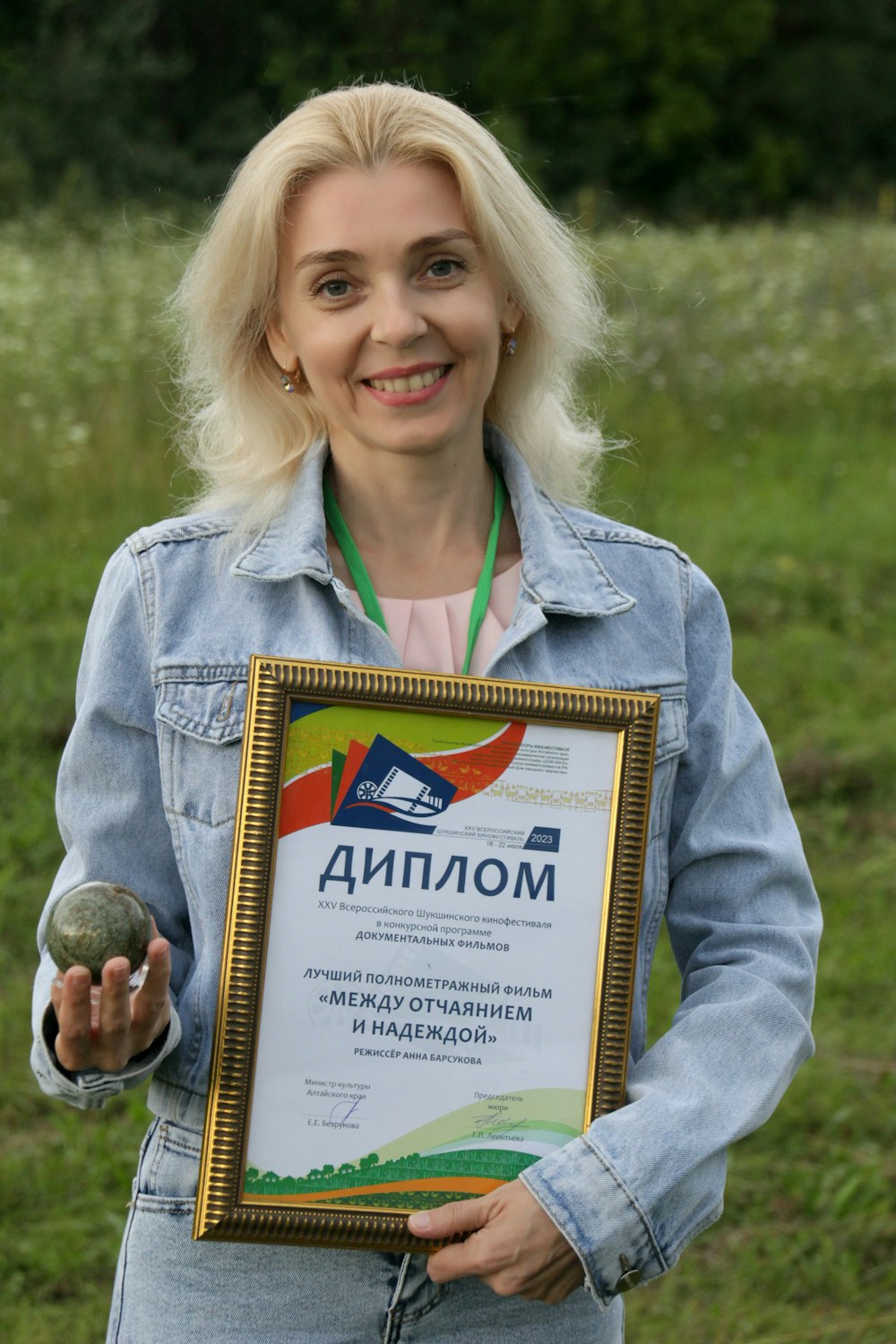 a woman holding a framed award in her hands