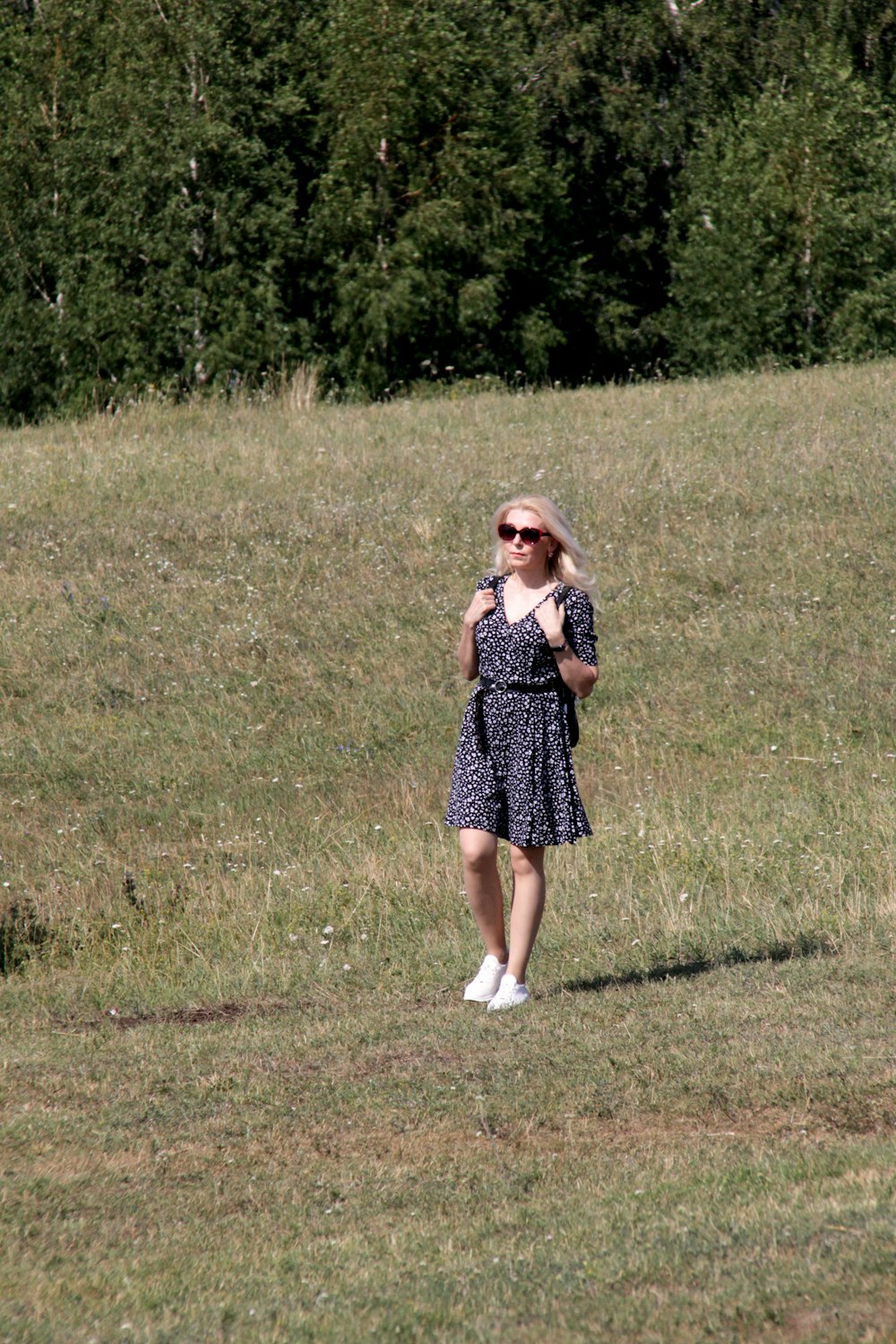 a woman standing in a field with a frisbee