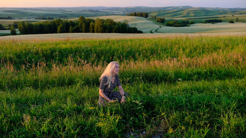 a woman walking through a lush green field